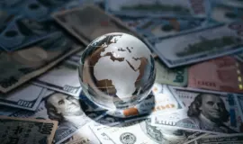 Glasglob över världskarta på dollarsedlar som symboliserar global spelmarknad inom onlinespel
