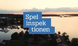 Spelinspektionens logotyp över flygfoto av svensk kuststad vid solnedgången