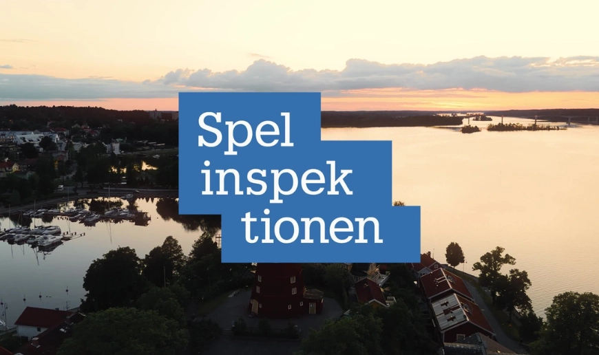 Spelinspektionens logotyp över flygfoto av svensk kuststad vid solnedgången