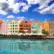 Färgglada hus längs hamnen i Willemstad på Curaçao under en blå himmel med moln. 
